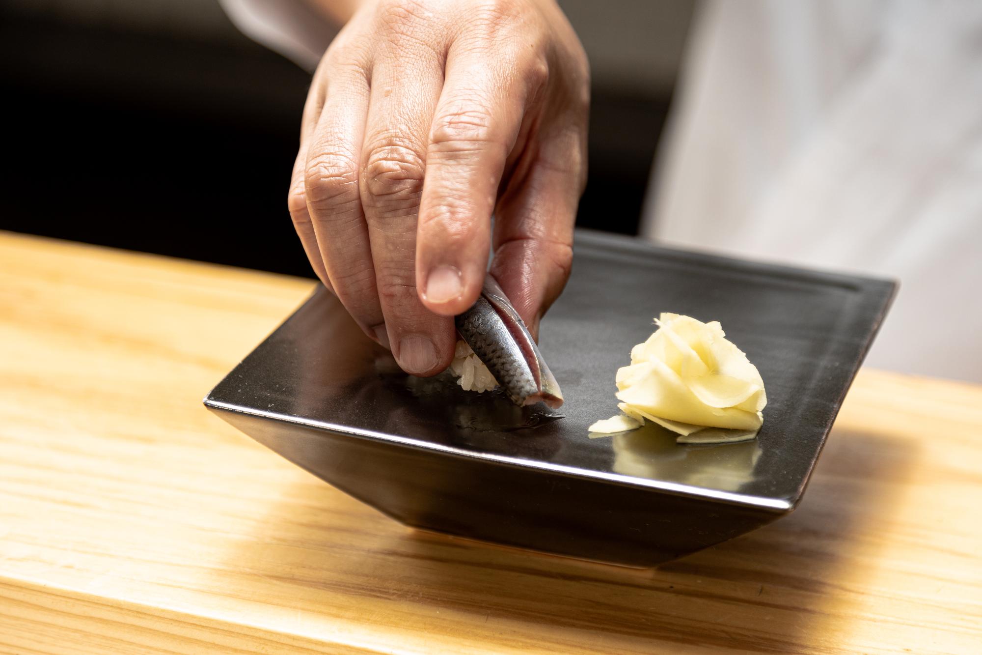 Chef arranging plated tasting menu on slate